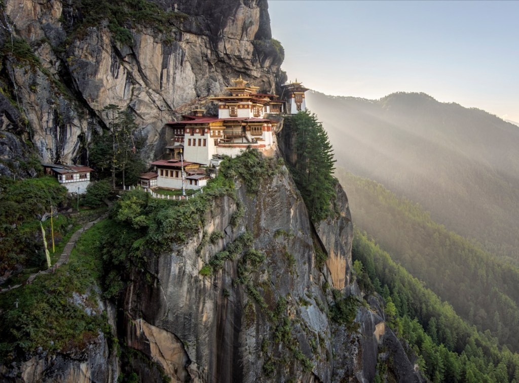 Tiger’s Nest Monastery in Bhutan, perched on a cliffside, representing spiritual dedication across lifetimes.